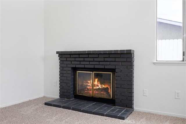room details featuring a fireplace, carpet, and baseboards