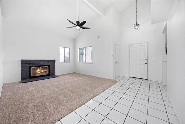unfurnished living room with beam ceiling, light colored carpet, a ceiling fan, a brick fireplace, and high vaulted ceiling