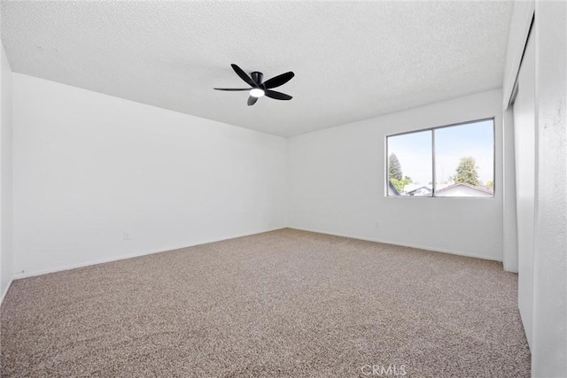 unfurnished room with a ceiling fan, carpet flooring, and a textured ceiling