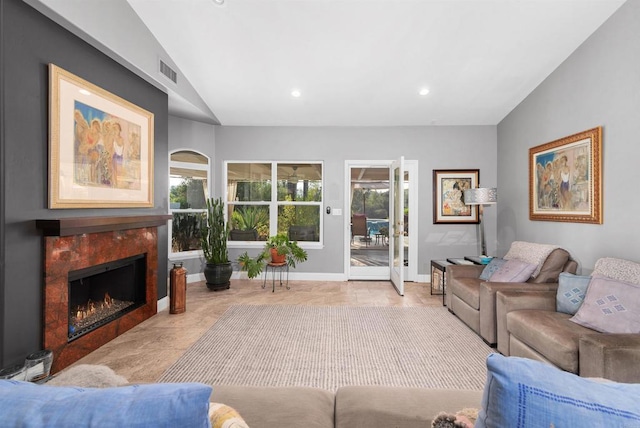 living area with baseboards, visible vents, lofted ceiling, recessed lighting, and a high end fireplace