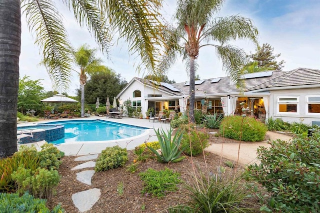 view of pool with a pool with connected hot tub, outdoor dining space, and a patio area