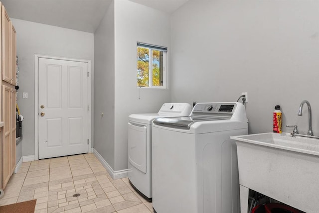 laundry area featuring a sink, light tile patterned floors, baseboards, laundry area, and washing machine and clothes dryer