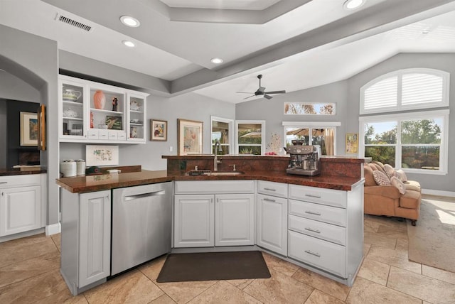 kitchen featuring visible vents, a sink, dark countertops, glass insert cabinets, and dishwasher