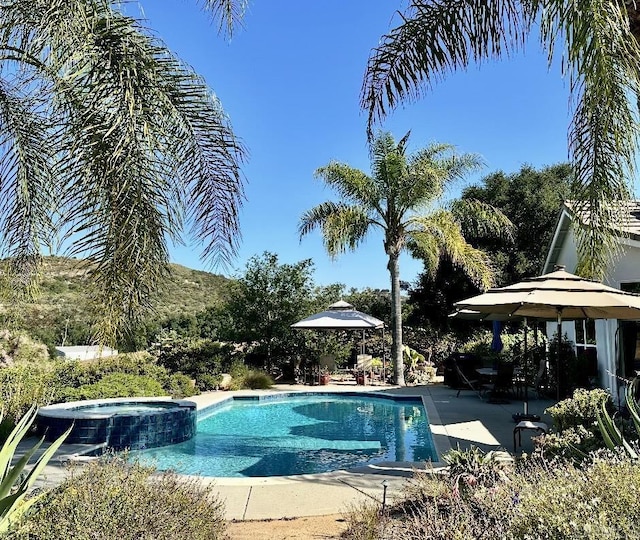 view of swimming pool with a pool with connected hot tub and a patio