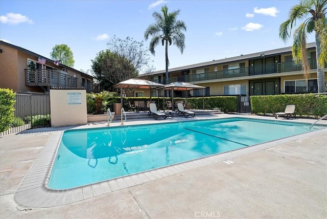 community pool featuring a patio and fence