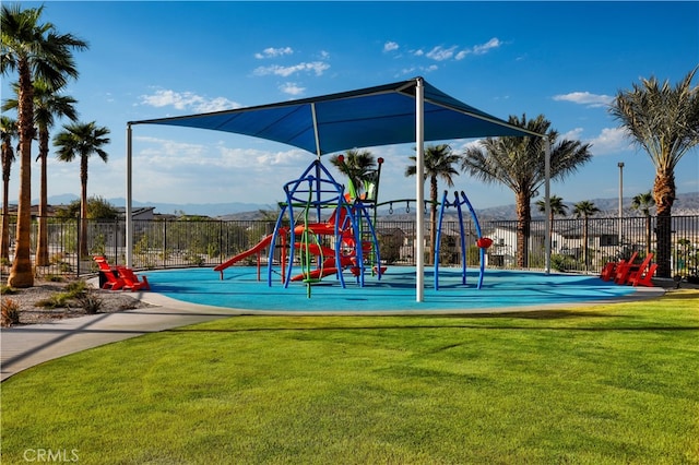 community play area with a lawn and fence