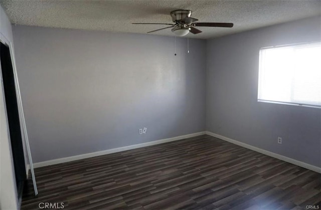 empty room with ceiling fan, baseboards, dark wood-style flooring, and a textured ceiling