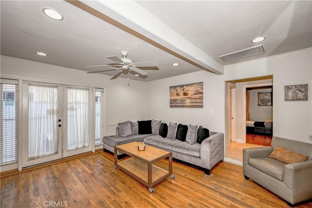 living room featuring crown molding, plenty of natural light, and light wood finished floors