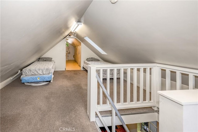 carpeted bedroom featuring vaulted ceiling with skylight