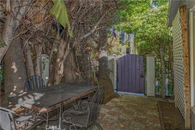 view of patio / terrace featuring outdoor dining area, a gate, and fence