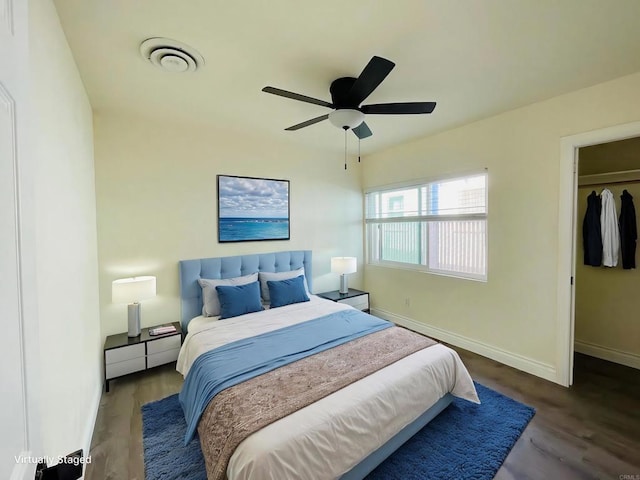 bedroom featuring visible vents, a ceiling fan, baseboards, and wood finished floors