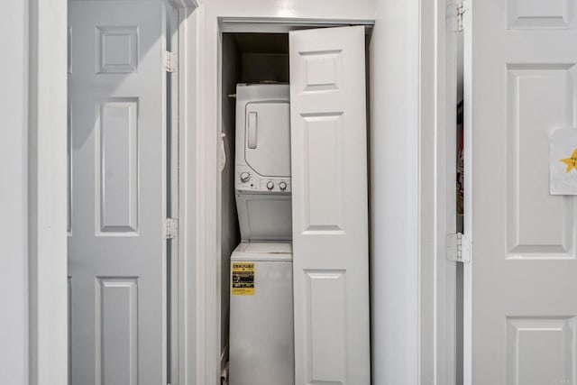 washroom with stacked washer / drying machine and laundry area