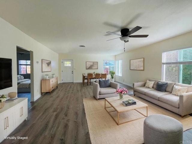 living room featuring dark wood-style floors, visible vents, ceiling fan, and baseboards