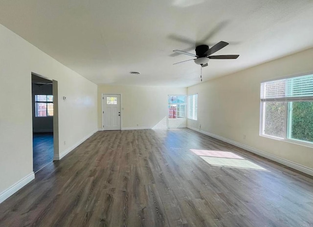 unfurnished living room featuring a ceiling fan, visible vents, wood finished floors, and baseboards