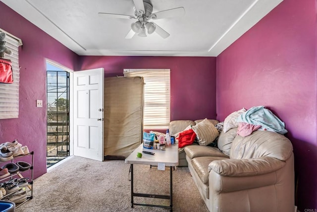 living area featuring carpet flooring and ceiling fan