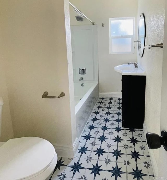 bathroom with vanity, baseboards, shower / bath combination, tile patterned floors, and toilet