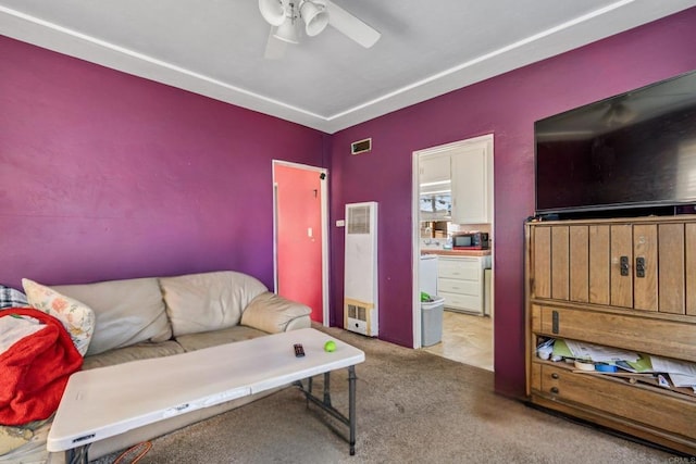 carpeted living room featuring visible vents and a ceiling fan