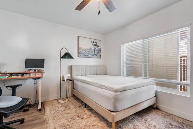 bedroom with ceiling fan, baseboards, and wood finished floors