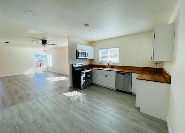 381214 36th St, San Diego, CA 92104 - kitchen with stainless steel appliances, a sink, light wood-style flooring, and baseboards