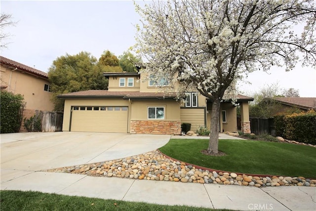 view of front of property featuring stucco siding, driveway, fence, a front yard, and a garage