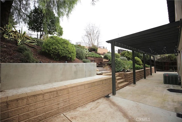 view of patio featuring central AC and fence