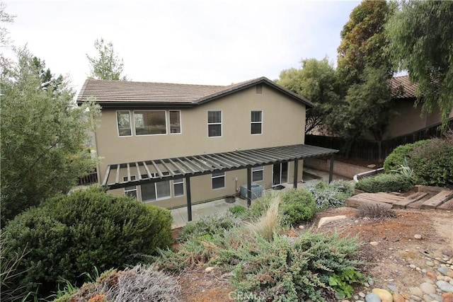 back of house with central air condition unit, stucco siding, a patio, and fence