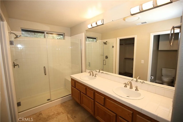 full bath with a sink, visible vents, double vanity, and a shower stall