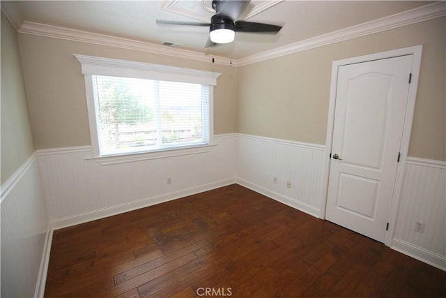 unfurnished room with visible vents, dark wood finished floors, and wainscoting