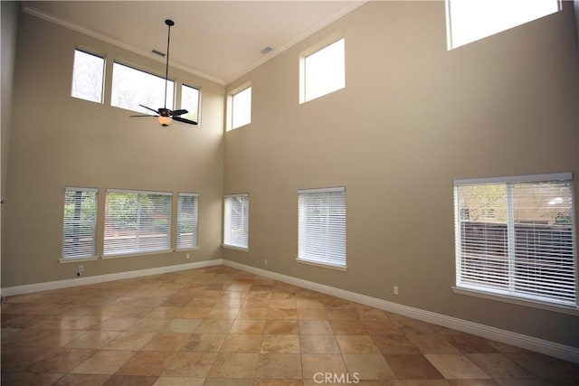 empty room featuring baseboards, a healthy amount of sunlight, ceiling fan, and crown molding