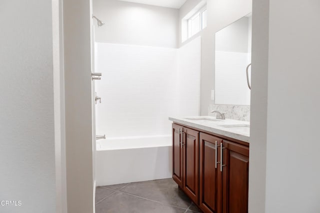 full bath with tile patterned flooring, double vanity, tub / shower combination, and a sink