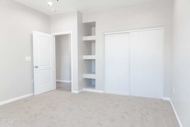 unfurnished bedroom with a closet, baseboards, and carpet floors