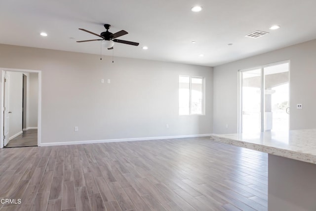 empty room with light wood-style flooring, recessed lighting, visible vents, and baseboards