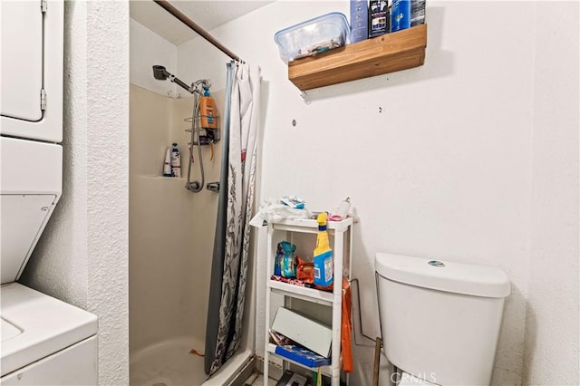 bathroom with a shower stall, toilet, and stacked washer / drying machine