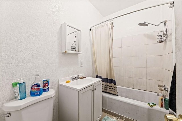 full bathroom featuring vanity, toilet, shower / bath combo with shower curtain, and a textured wall