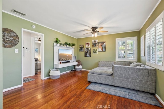 living area with visible vents, crown molding, ceiling fan, and wood finished floors