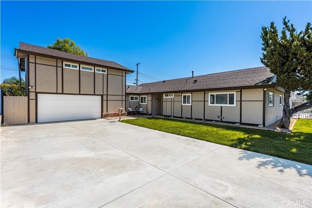 view of front of home featuring stucco siding, a garage, a front lawn, and fence