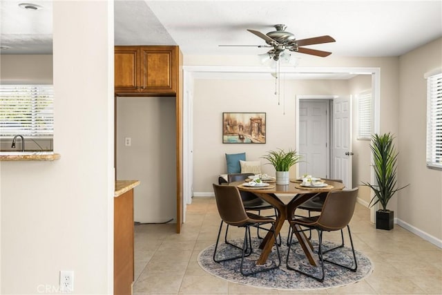 dining space with light tile patterned floors, ceiling fan, and baseboards