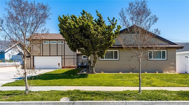 view of front of property with driveway, an attached garage, a front yard, and fence