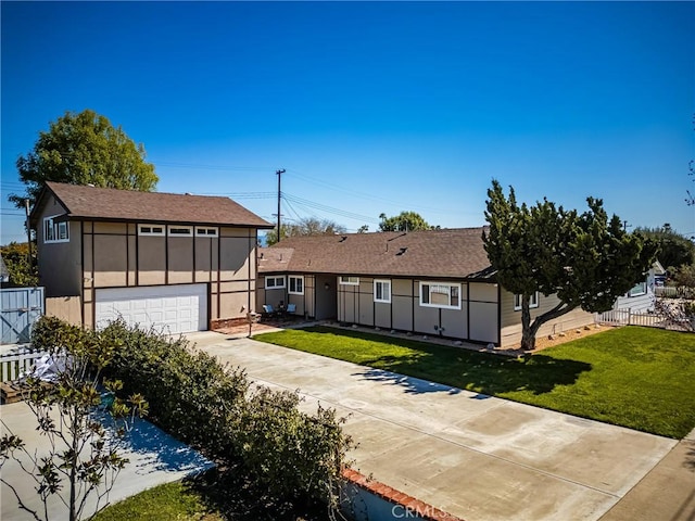 view of front of property with a garage, stucco siding, a front yard, and fence