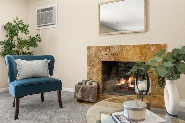 living area with a fireplace, carpet, a wall mounted AC, and baseboards