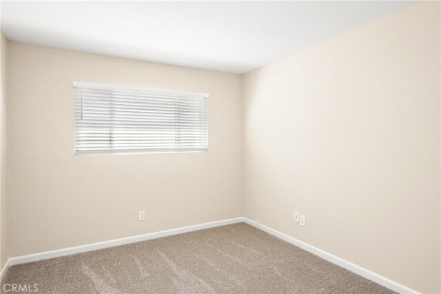 carpeted spare room with baseboards