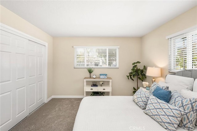 carpeted bedroom with a closet and baseboards