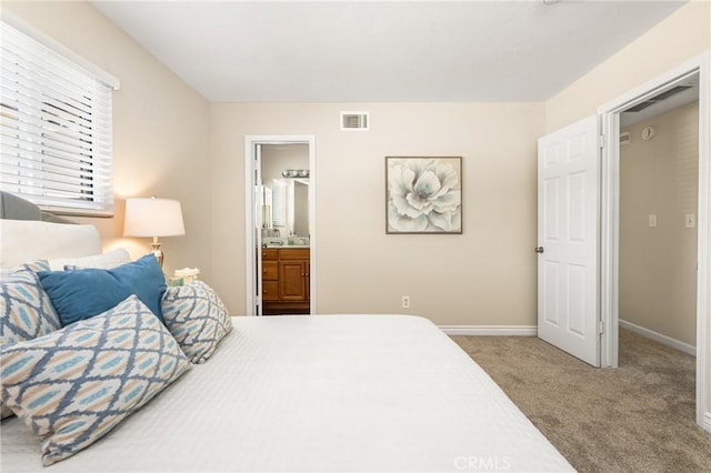 bedroom with ensuite bath, visible vents, baseboards, and carpet