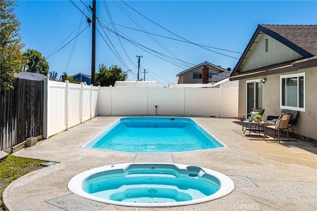 view of pool featuring a patio area, a fenced in pool, an in ground hot tub, and a fenced backyard