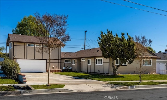 view of front of home featuring a garage, concrete driveway, a front lawn, and fence