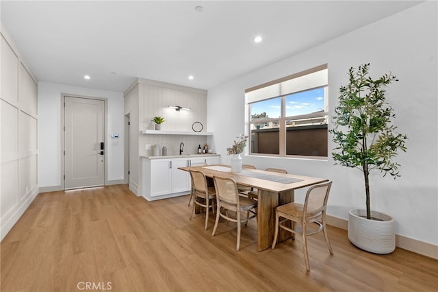 dining room featuring light wood finished floors, recessed lighting, and baseboards