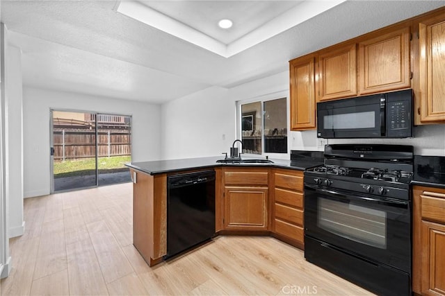 3266 Ashgate Ct, Ontario, CA 91761 - kitchen featuring a sink, a peninsula, brown cabinetry, dark countertops, and black appliances