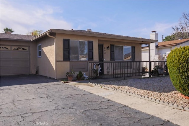 view of front facade with stucco siding, an attached garage, and driveway