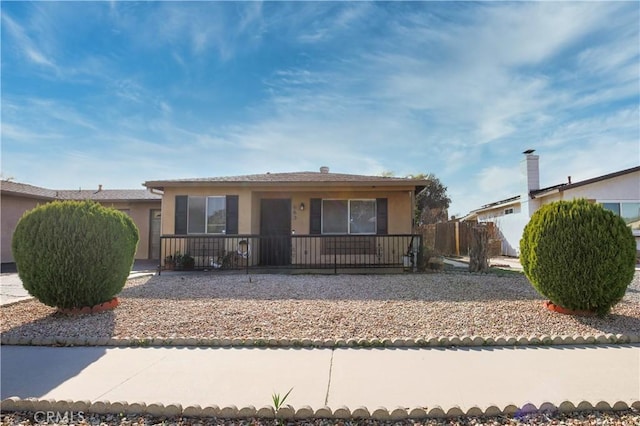 view of front of home featuring stucco siding and fence