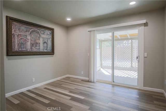 unfurnished room with recessed lighting, baseboards, and wood finished floors